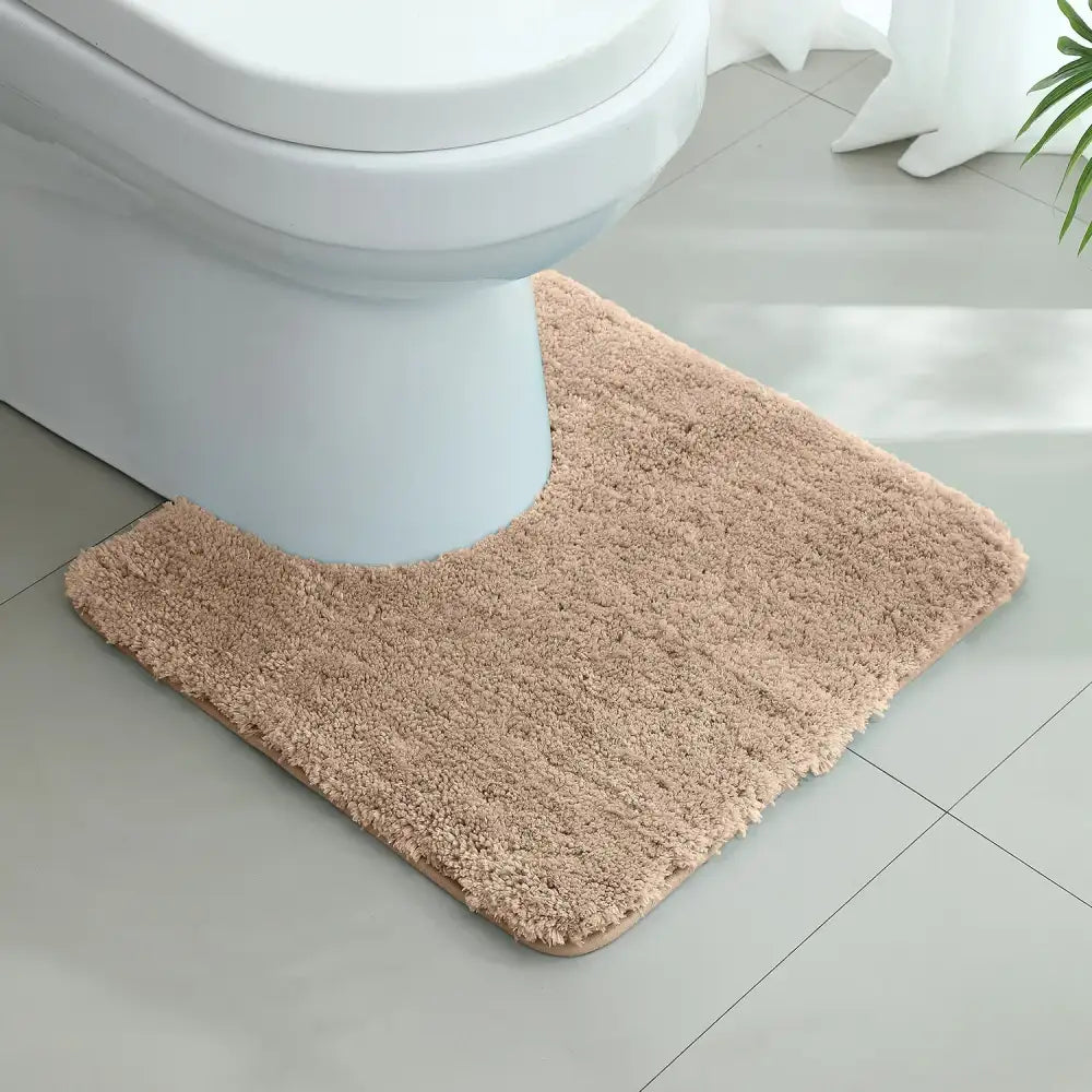 Tapis contour wc beige en tissu pelucheux doux avec texture shaggy et coins arrondis pour salle de bain