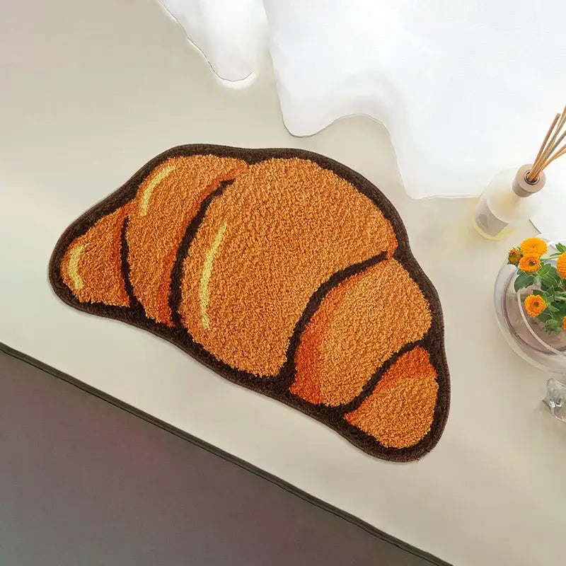 Tapis de bain en forme de croissant avec croûte dorée-brun et garniture brun clair, fabriqué en matériau moelleux.