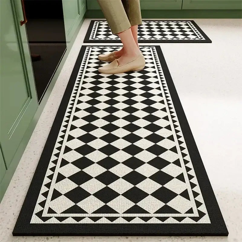 Tapis de cuisine à carreaux noir et blanc avec une surface texturée, probablement fabriqué en caoutchouc ou en vinyle.