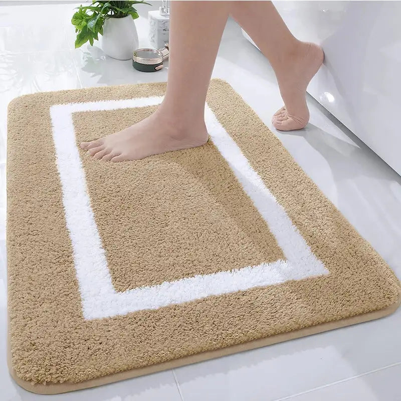 Tapis de bain beige avec bordure blanche, matériau microfibre doux.