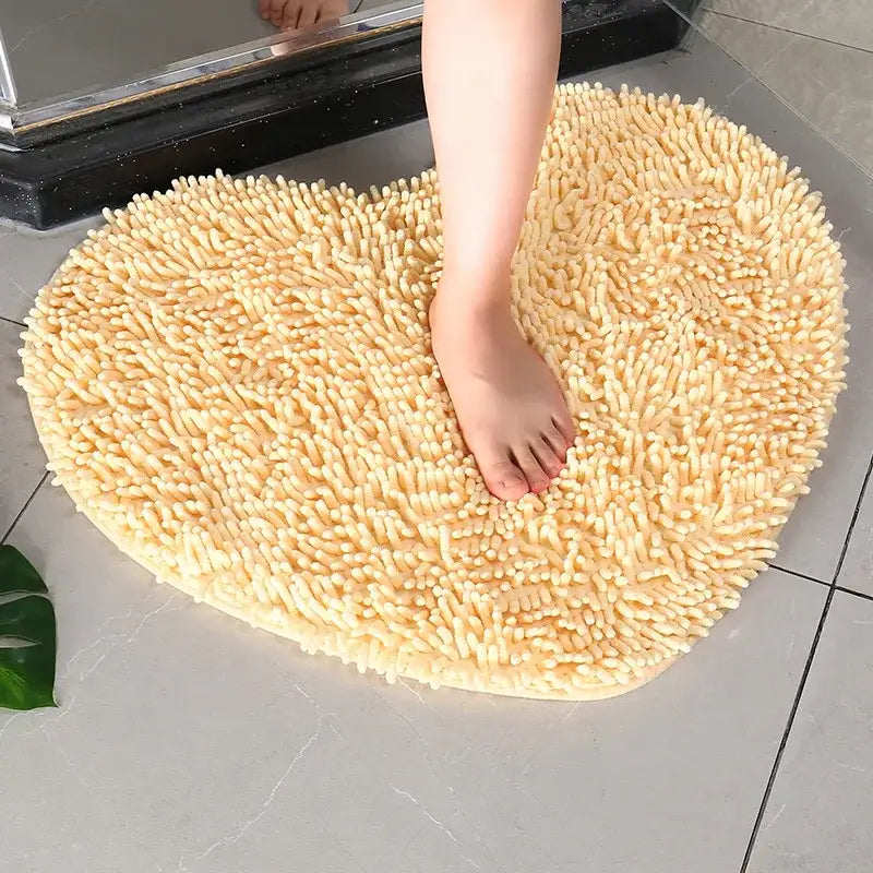 Tapis de bain en forme de cœur, couleur beige avec surface texturée, matériau moelleux pour le confort et la résistance au glissement.