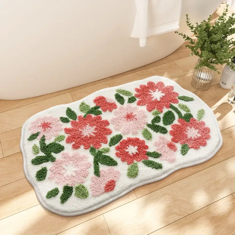 Tapis de bain floral avec des fleurs roses et vertes sur un fond blanc, fabriqué en matériau moelleux.
