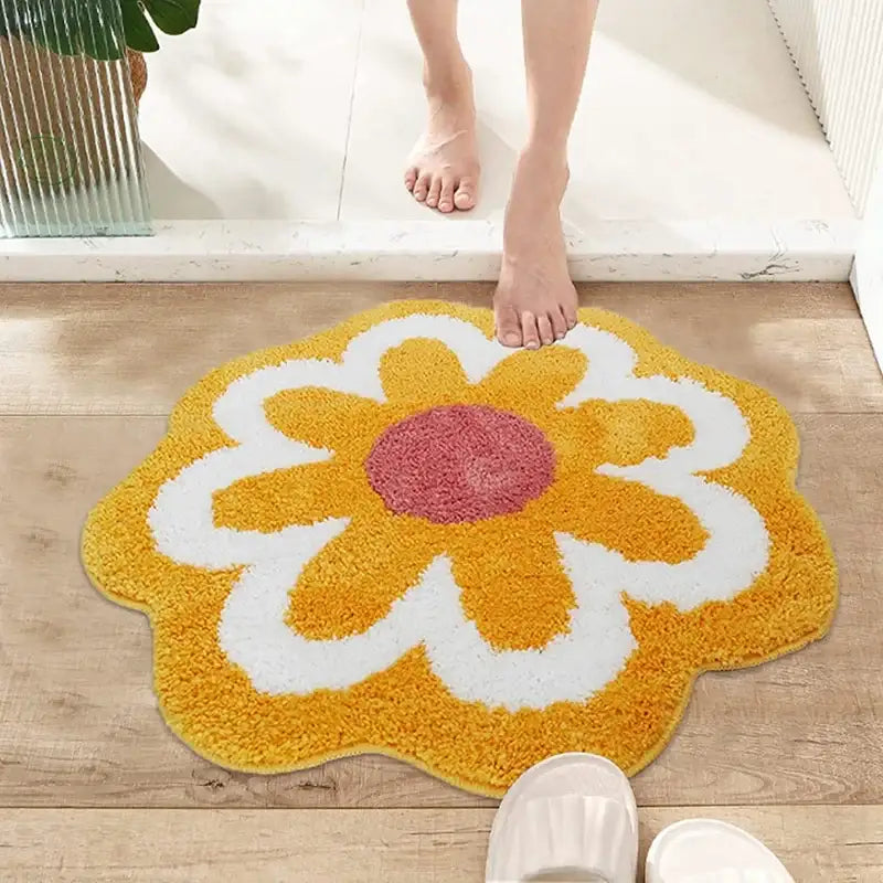 Tapis de bain en forme de fleur jaune avec des accents blancs et roses, fabriqué en matériau moelleux.