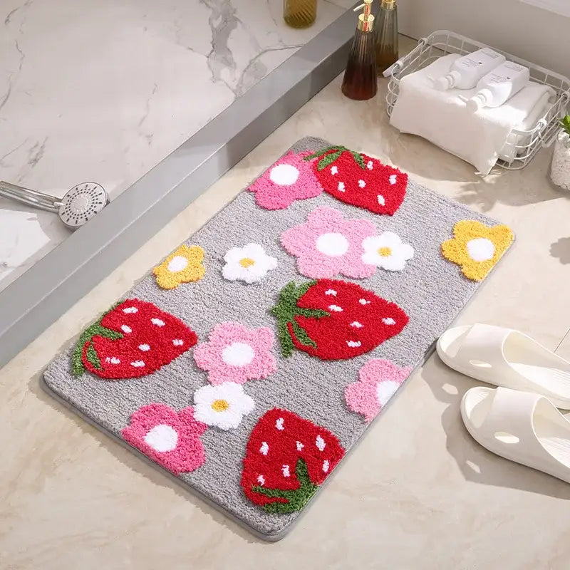 Tapis de bain à thème fraise avec des couleurs vives et un design texturé, probablement fabriqué en microfibre ou un matériau similaire.