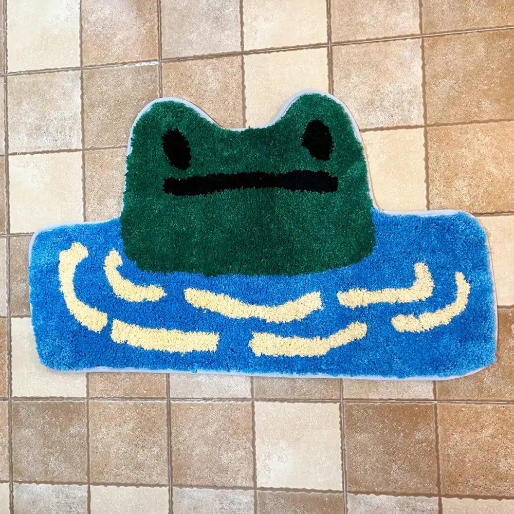 Tapis de bain en peluche verte en forme de grenouille avec des détails d’eau bleue et de vague jaune