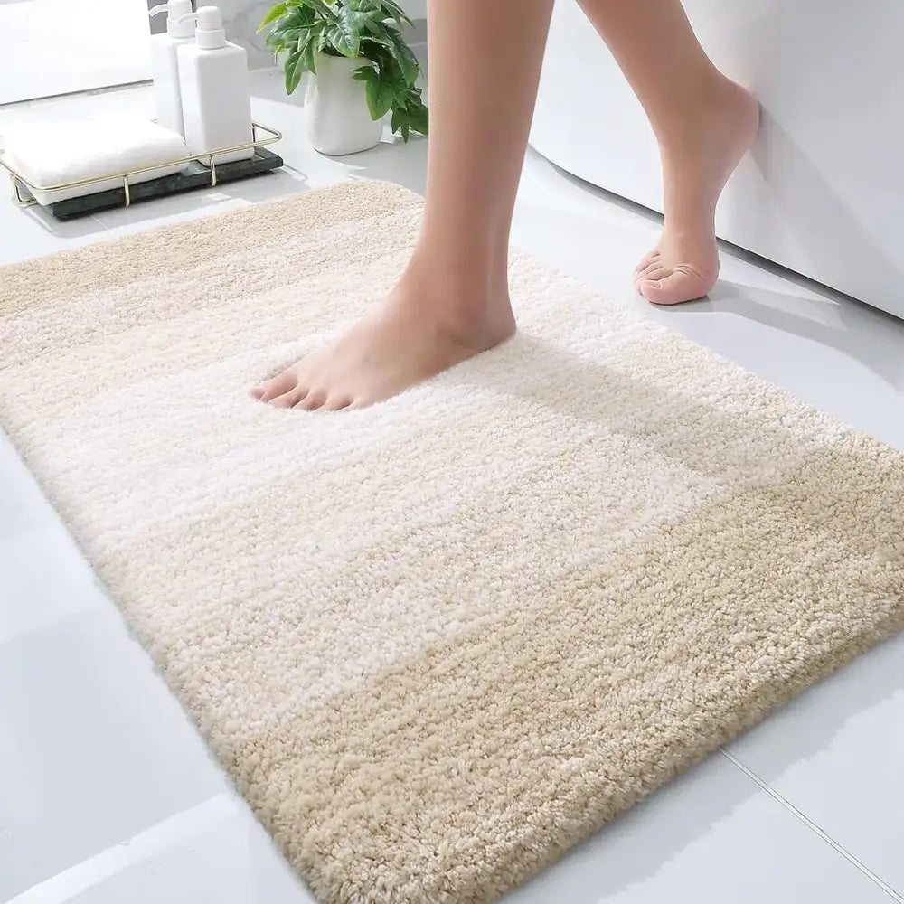 Tapis de bain crème, moelleux, avec une surface texturée douce et un dégradé subtil vers le beige aux bords.