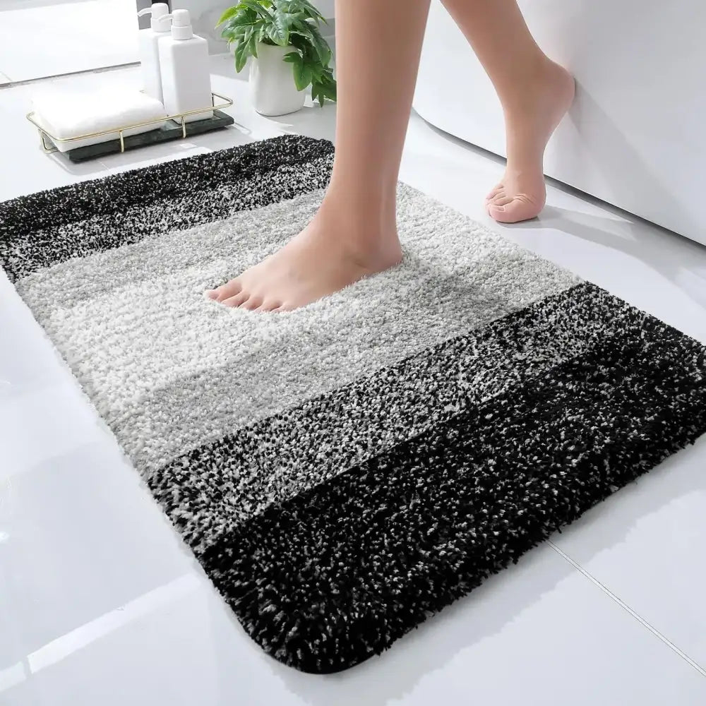 Un tapis de bain moelleux à rayures noir et blanc avec une surface douce et texturée.
