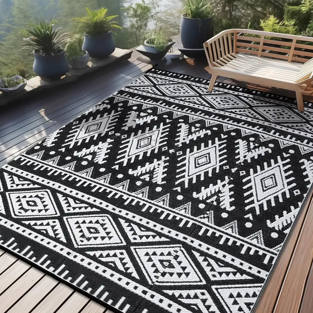 Tapis d’extérieur à motif géométrique noir et blanc avec un design moderne.