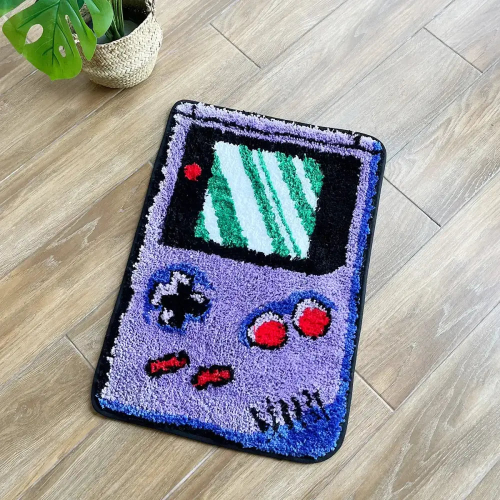 Tapis Game Boy violet avec écran vert et boutons rouges.