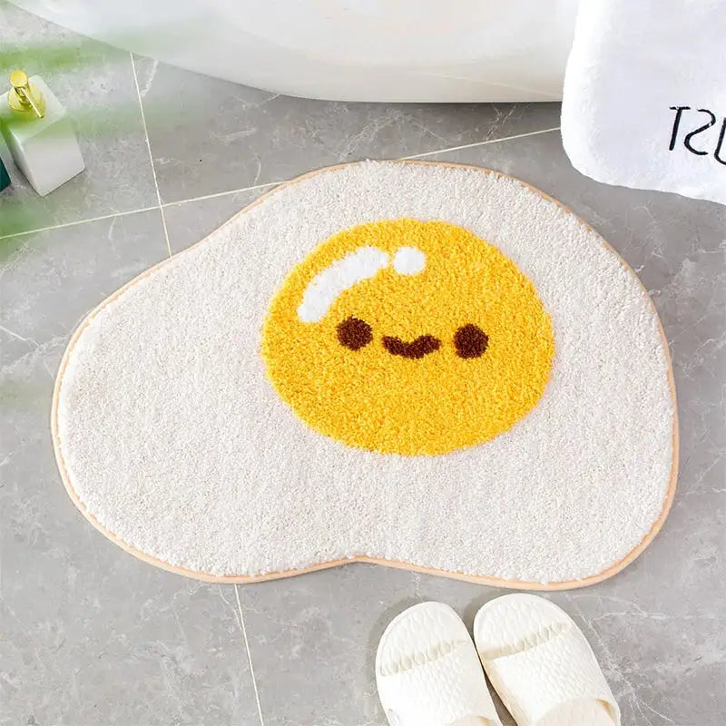 Tapis de bain œuf au plat avec design visage mignon, matériau jaune et blanc.