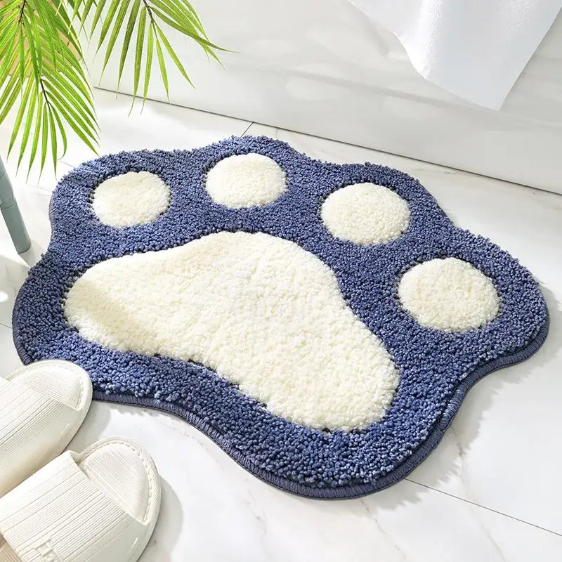 Tapis de bain bleu et blanc avec empreinte de patte et velours texturé.