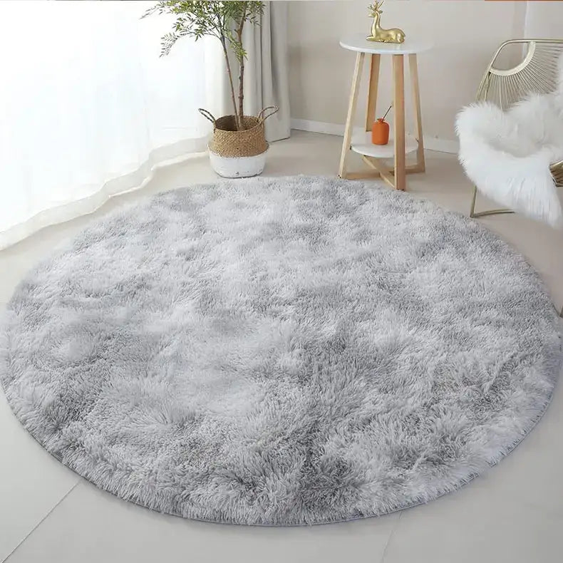 Tapis rond gris à poils longs avec une texture moelleuse et une apparence douce, probablement fabriqué à partir de fibres synthétiques.