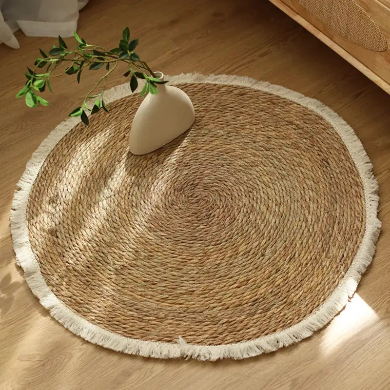 Tapis tissé rond en herbe de mer avec franges blanches, couleur marron naturel et design rustique.