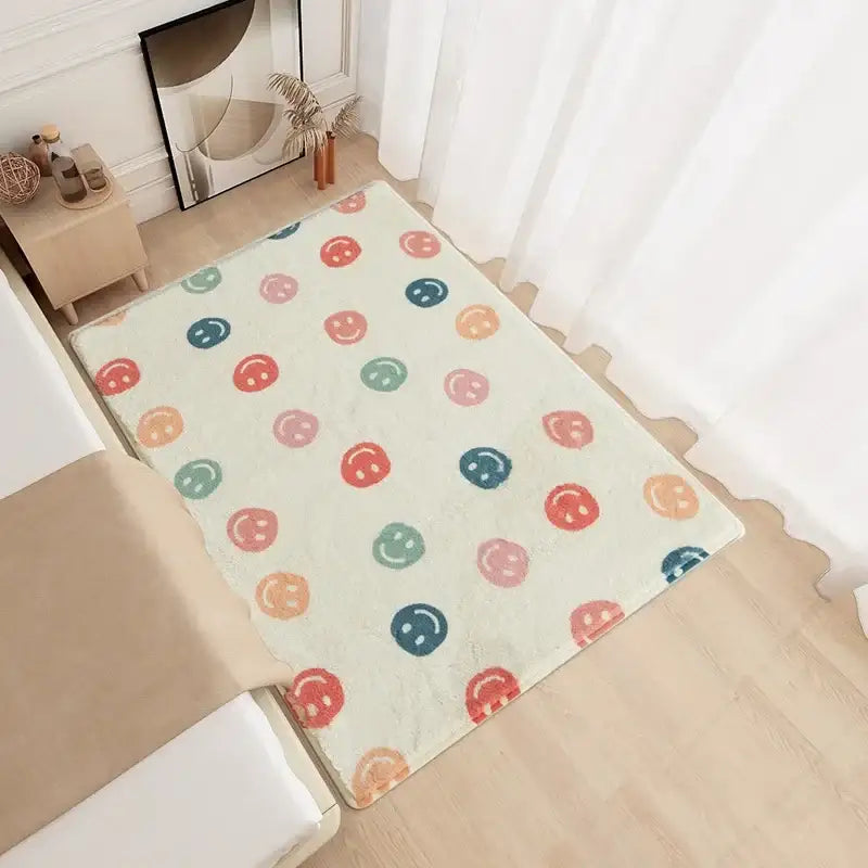Tapis avec un visage souriant blanc et des motifs colorés sur un sol en bois.