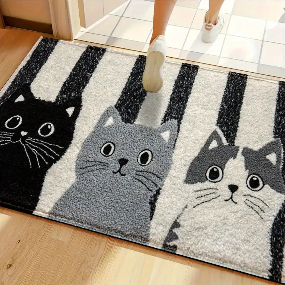 Un tapis moelleux à rayures noir et gris orné de trois chats de dessin animé aux yeux expressifs et aux moustaches.