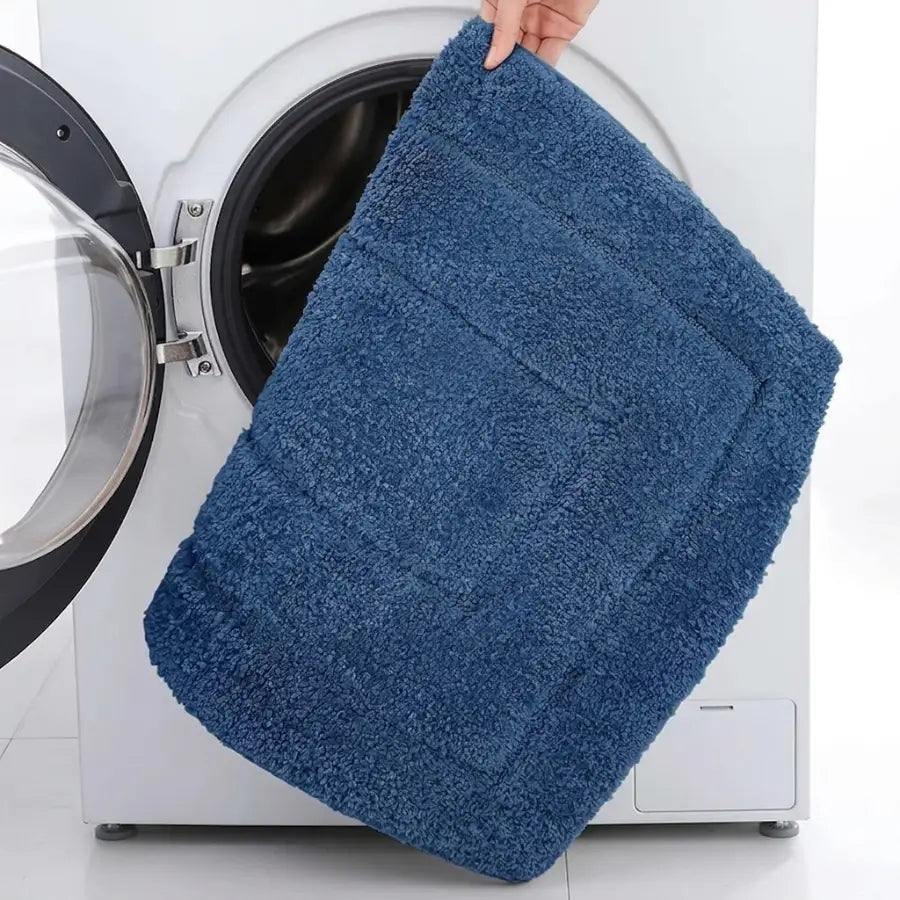 Tapis de bain bleu pétrole en tissu éponge texturé avec bordure subtilement cousue pour un bain bleu pétrole confortable