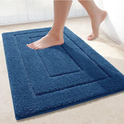 Tapis de bain bleu pétrole en tissu pelucheux avec texture bouclée et bordure surélevée pour un bain bleu pétrole élégant