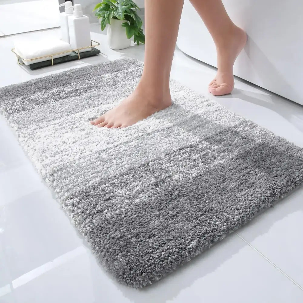Tapis de bain gris doux et moelleux avec un effet dégradé du clair au foncé.