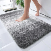 Tapis de bain gris dégradé doux et moelleux à texture shaggy.