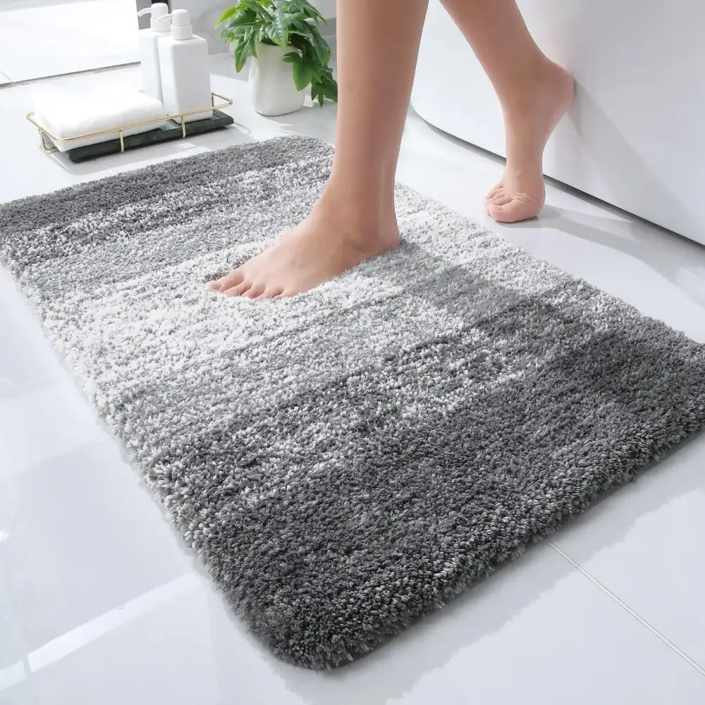 Tapis de bain gris dégradé doux et moelleux à texture shaggy.