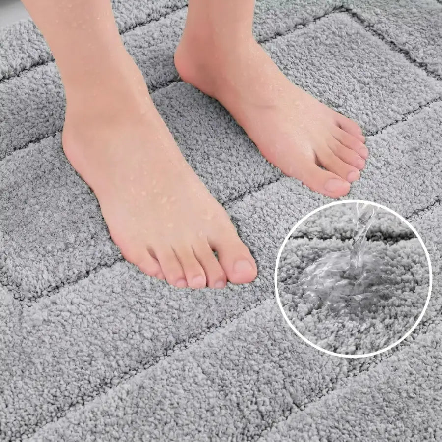 Tapis de bain gris perle en peluche avec surface texturée et sections carrées imbriquées pour un confort optimal