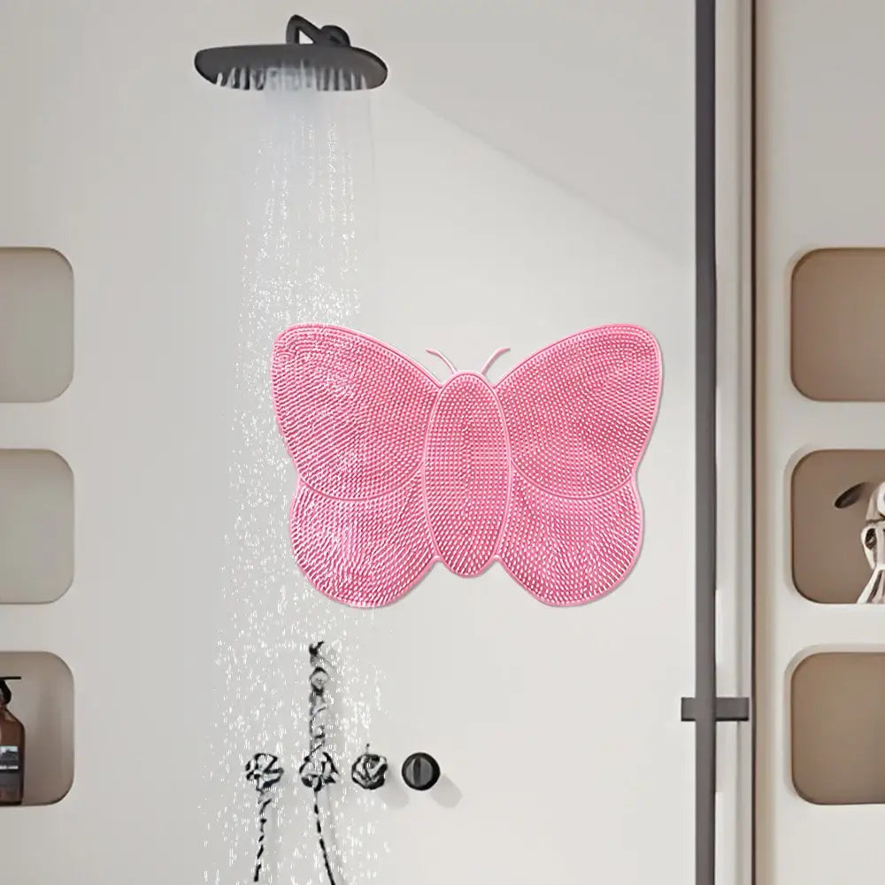 Tapis de douche en forme de papillon rose avec une surface texturée antidérapante.