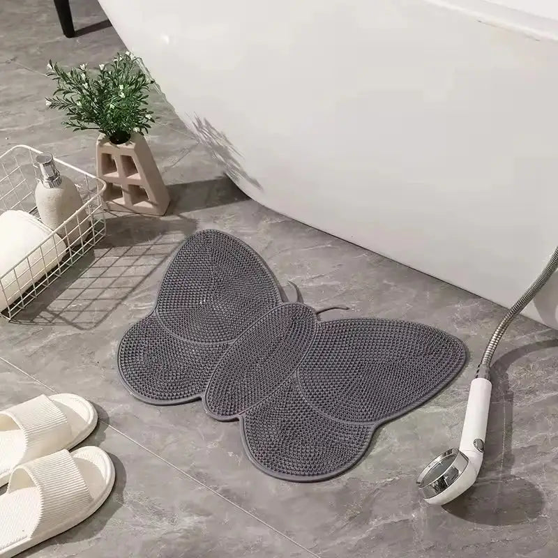 Tapis de bain gris en forme de papillon avec une surface texturée, semblable à un treillis.