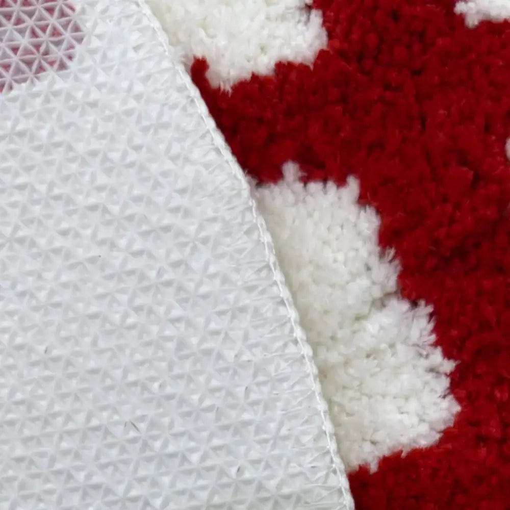 Tapis de bain texturé blanc avec un motif rouge et blanc, probablement fabriqué en microfibre ou un matériau similaire.