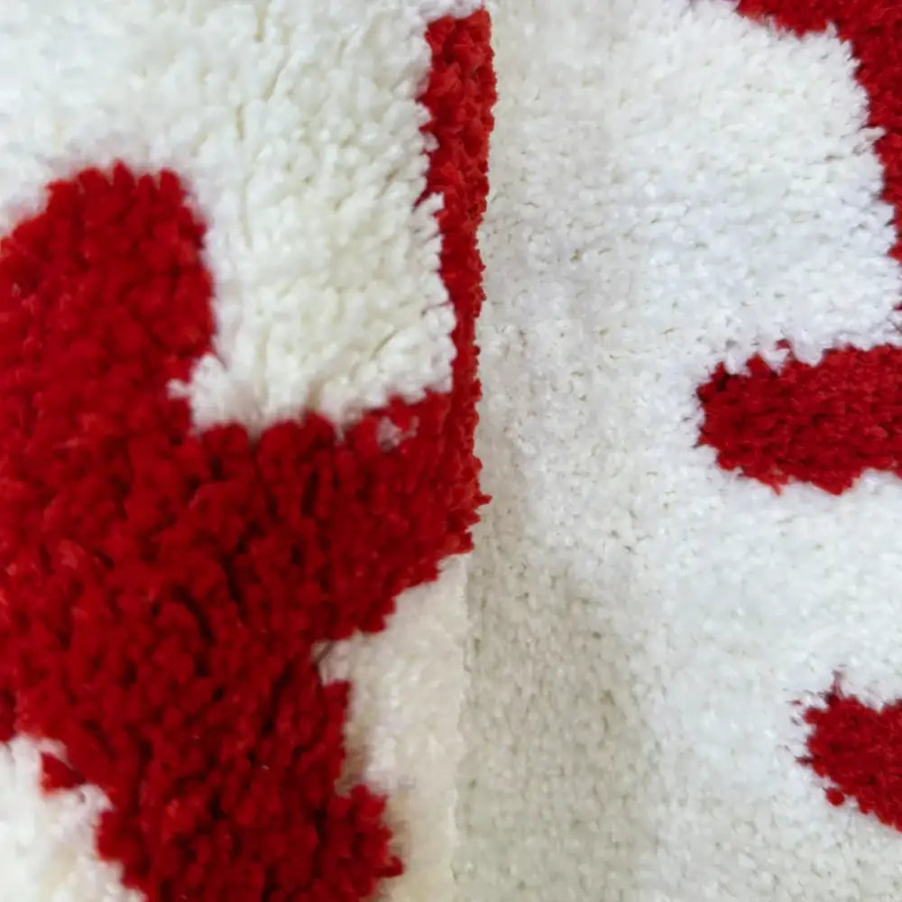 Tapis en forme de cœur rouge et blanc à texture moelleuse.