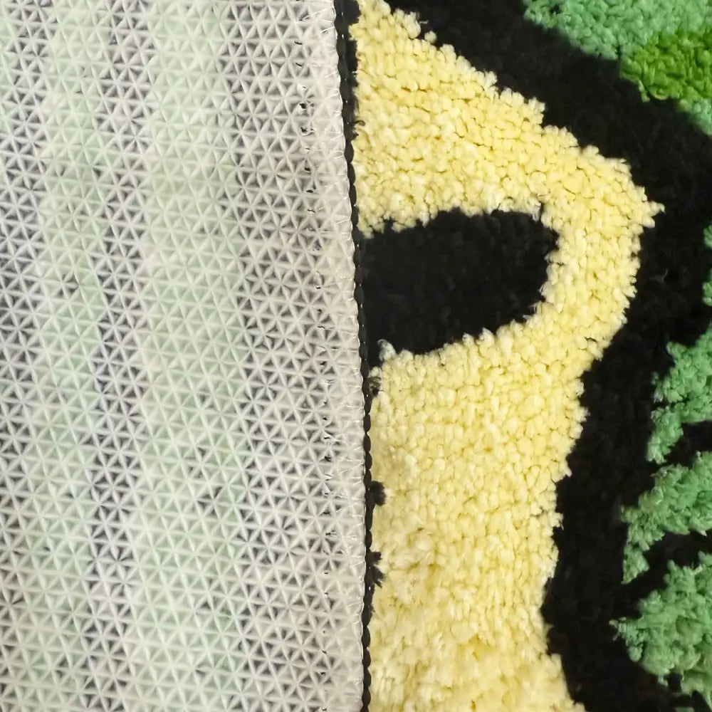 Tapis jaune et noir avec motif géométrique, probablement fabriqué à partir de fibres synthétiques.