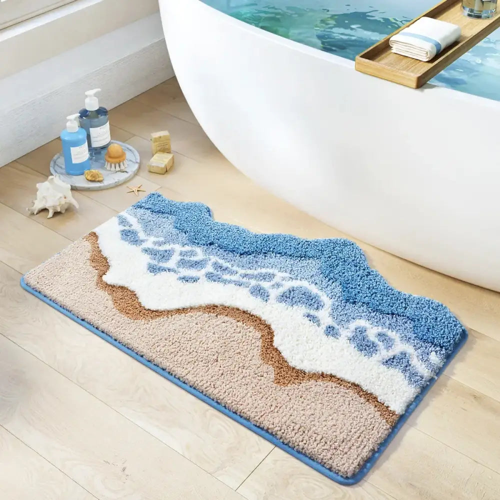 Tapis de bain à thème plage avec design de vagues océaniques et rivage sableux, bordure bleue, matériau moelleux.