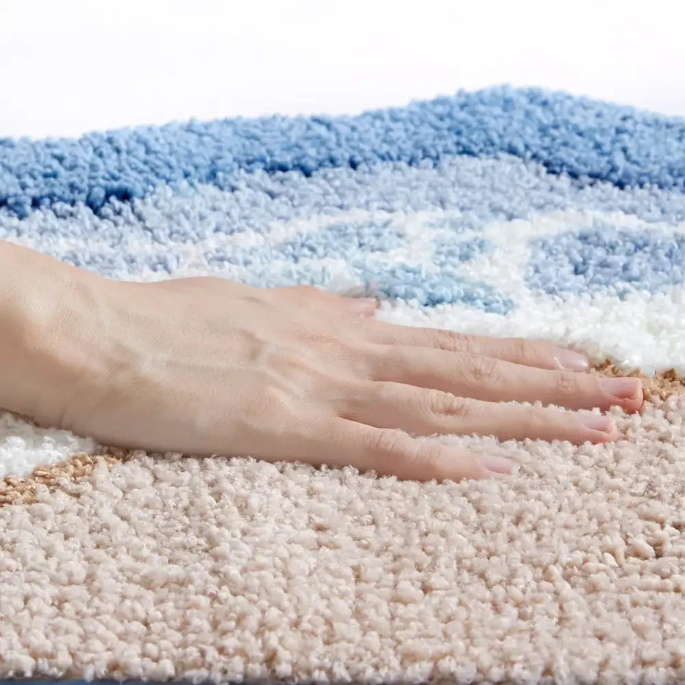 Tapis de bain texturé de couleur crème avec motif de vague bleue, matériau moelleux.