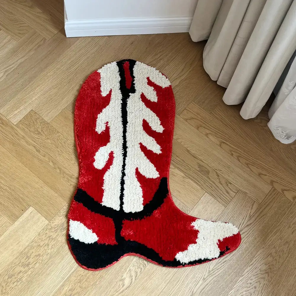 Tapis en forme de botte de cowboy rouge, blanche et noire avec une surface moelleuse et texturée.