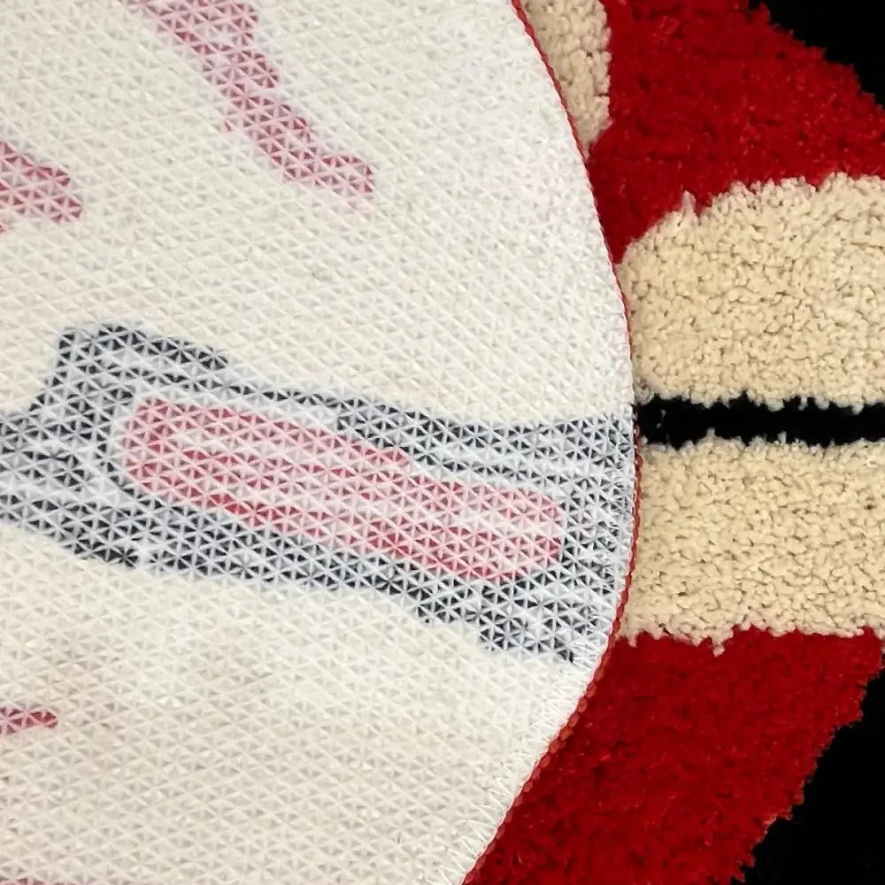 Tapis texturé blanc avec des sections moelleuses rouges et beige ornées d’un motif géométrique.