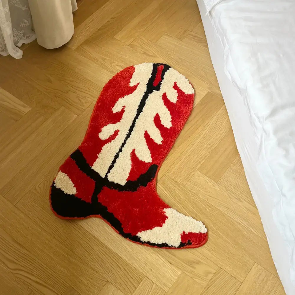 Tapis en forme de botte de cow-boy rouge, crème et noir avec une surface moelleuse et texturée.