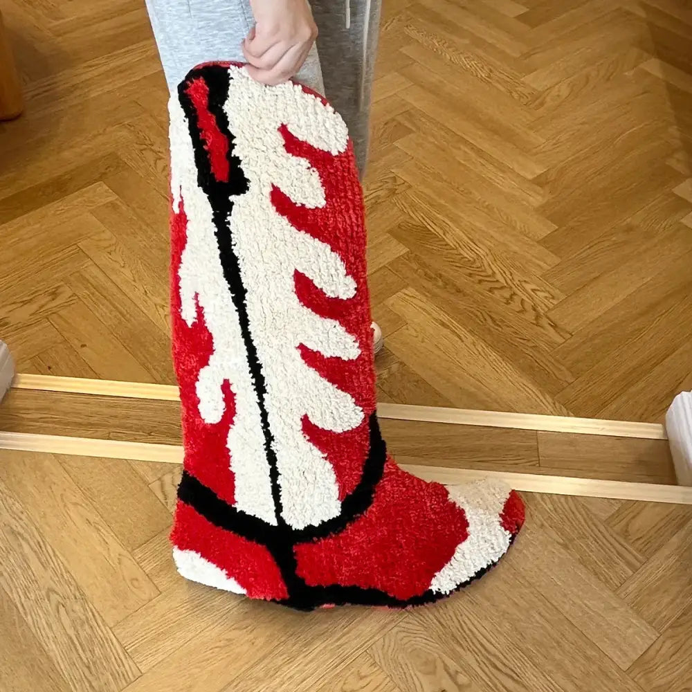 Tapis en peluche en forme de botte de cowboy rouge, blanc et noir.