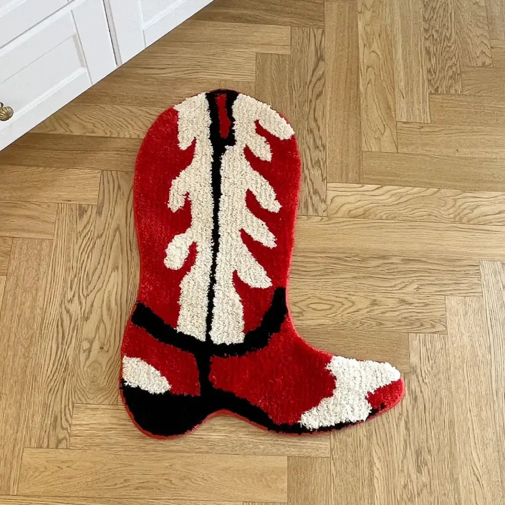 Tapis en forme de botte de cowboy rouge, crème et noir avec une surface moelleuse et texturée.
