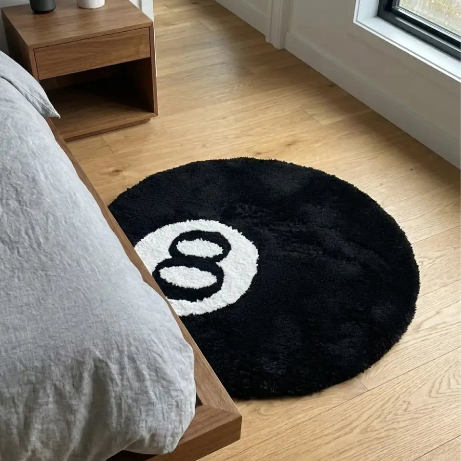Tapis en forme de boule 8 avec un design noir et blanc, matériau moelleux.