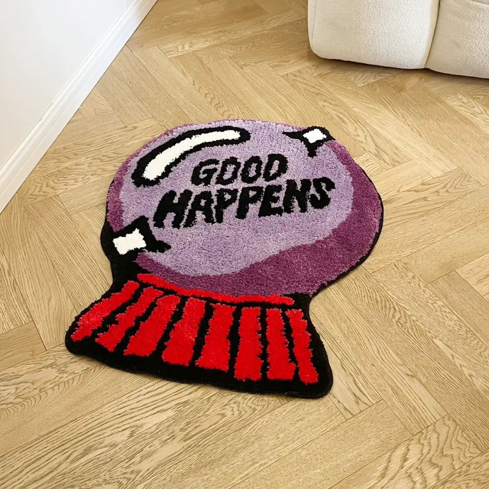 Tapis de bain distributeur de bonbons violet et rouge avec message inspirant « good happens » dessus.