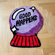 Tapis de bain boule de cristal violette avec le texte « good happens » en noir et blanc.