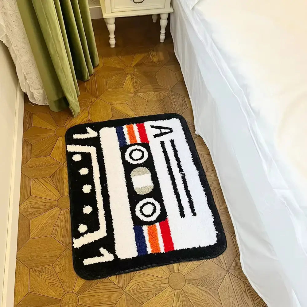 Tapis cassette noir et blanc en peluche avec support caoutchouc imitant une cassette vintage à rayures colorées