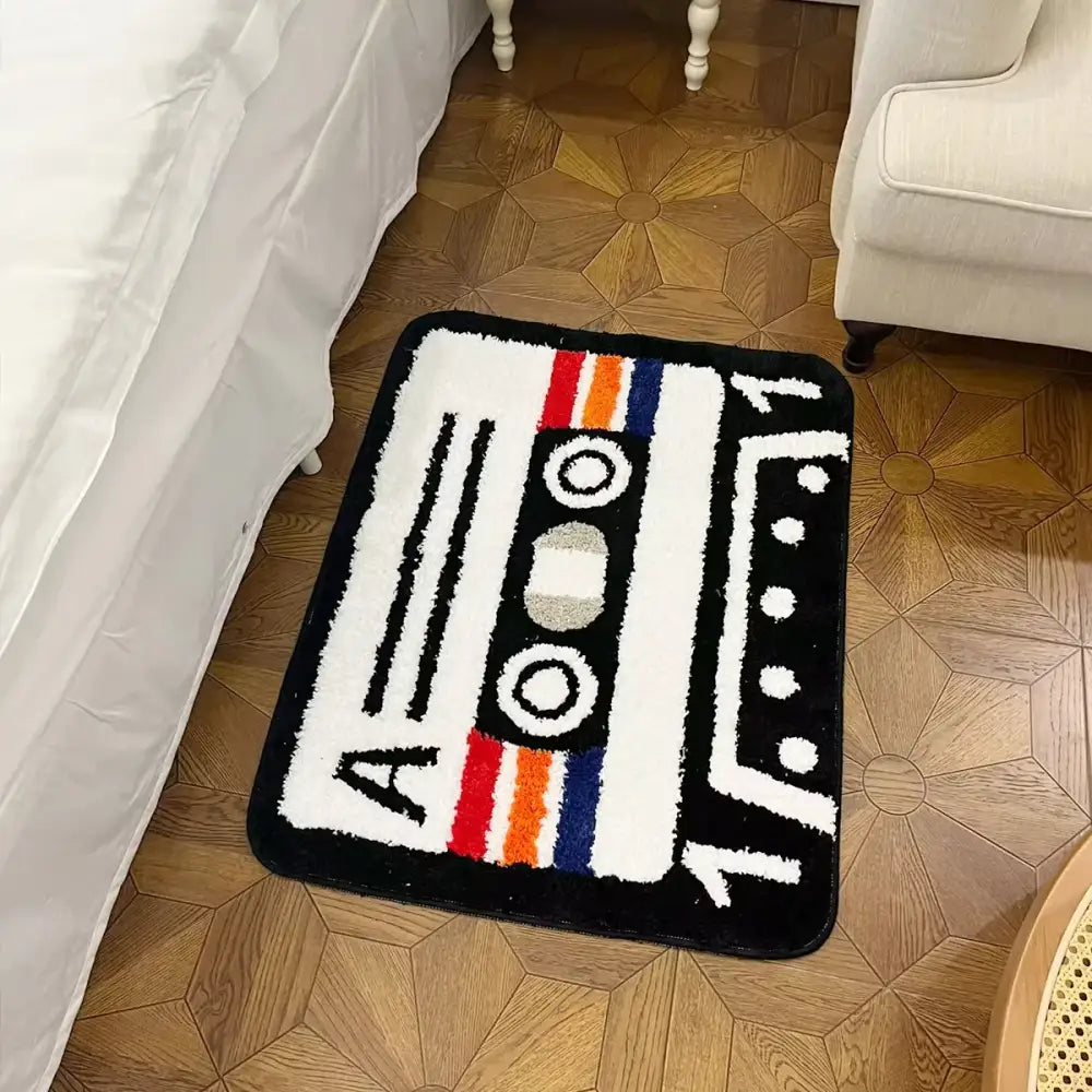 Tapis cassette en peluche noir et blanc avec rayures colorées et support caoutchouc antidérapant vintage