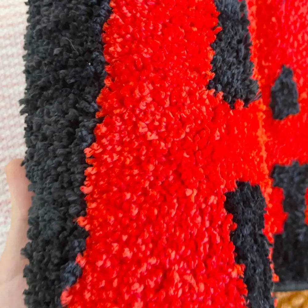 Tapis chambre garçon rouge et noire en tissu pelucheux à rayures avec surface texturée et douce idéale pour chambre garçon rouge