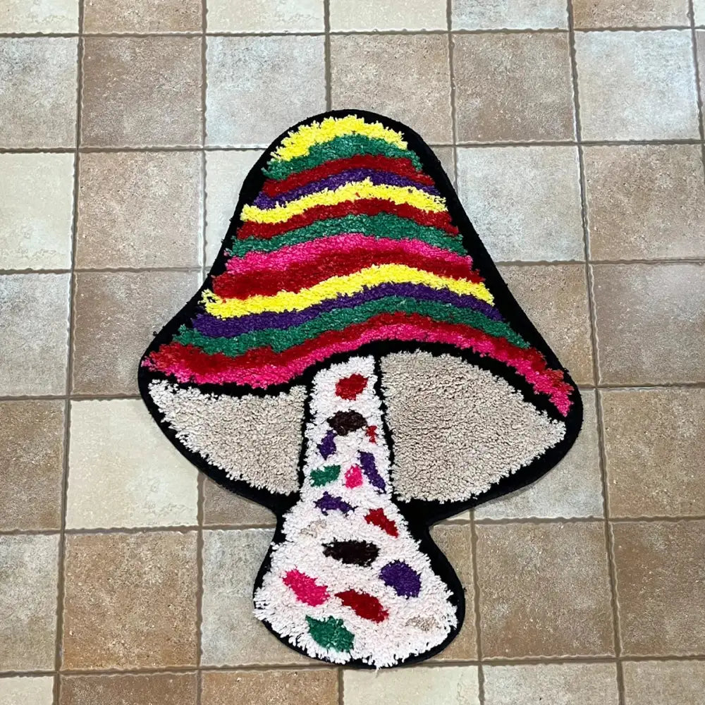 Tapis de bain champignon à rayures arc-en-ciel avec tige colorée et chapeau blanc, fabriqué en matériau moelleux.