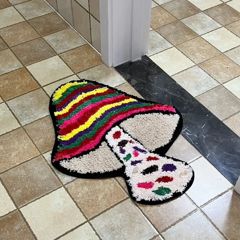 Tapis de bain champignon arc-en-ciel avec base noire, matériau doux et design vibrant.