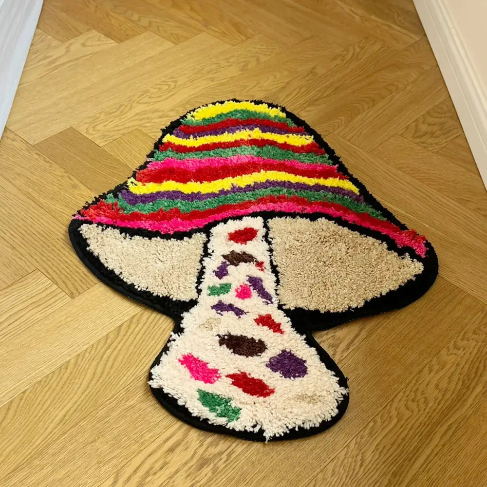 Tapis de bain champignon arc-en-ciel avec bordure noire et chapeau rayé coloré, fabriqué en matériau moelleux.