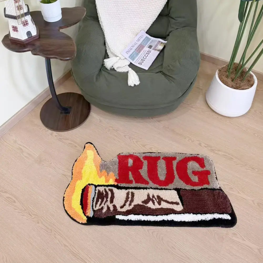 Un tapis moelleux en forme de flamme conçu pour ressembler à une allumette en train de brûler avec le mot « tapis » en lettres rouges grasses au centre.