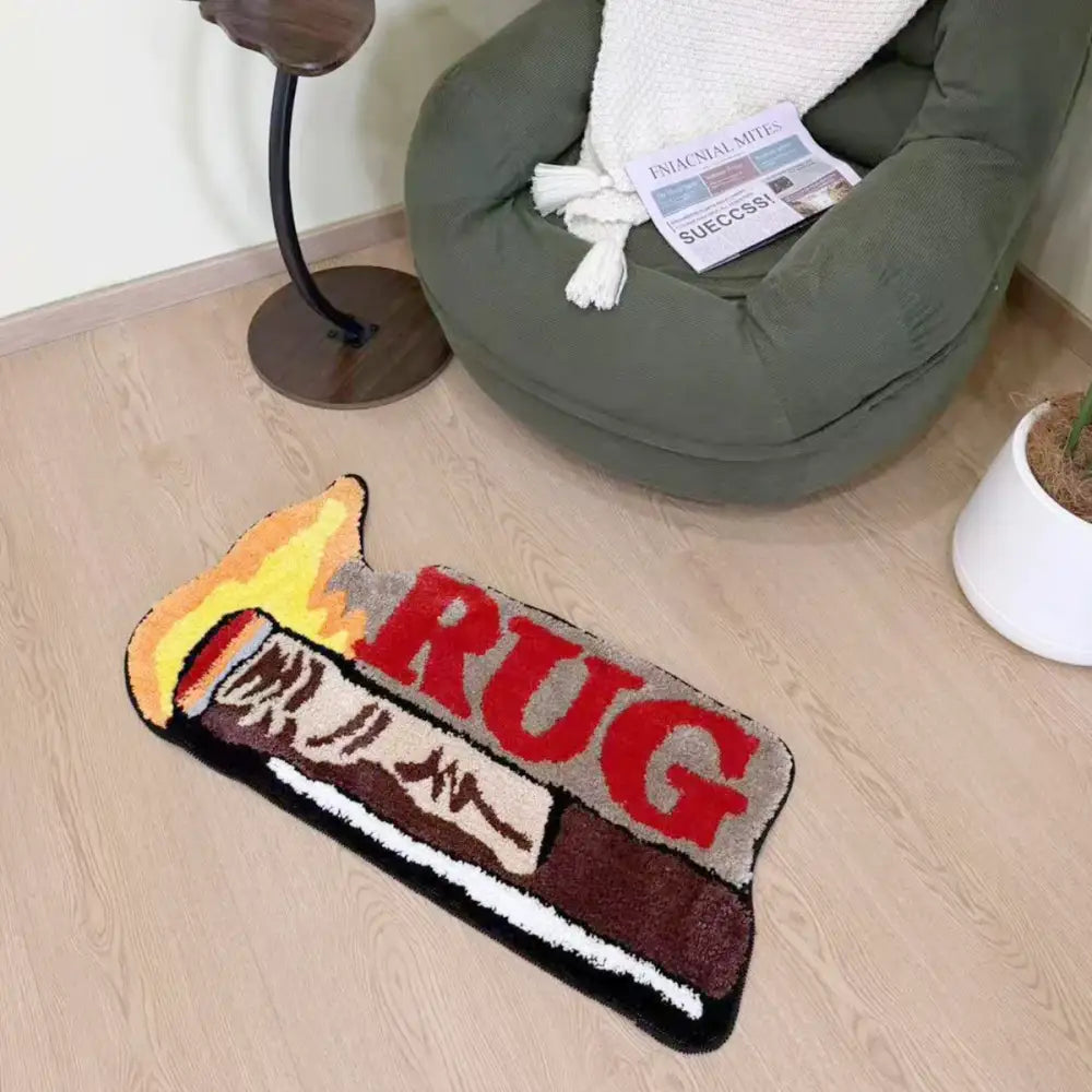 Un tapis fantaisiste en forme de flamme avec une inscription en rouge audacieux épelant « tapis » et un design texturé ressemblant à une allumette.