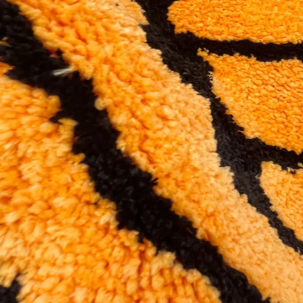 Tapis de bain à rayures tigrées avec des rayures orange et noires, matériau moelleux.