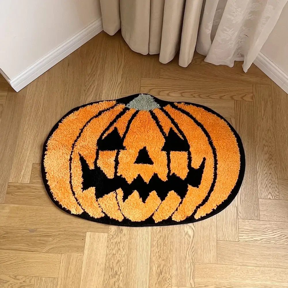 Tapis de bain citrouille d’Halloween orange avec yeux et bouche noirs, tige grise, sur un sol en bois.